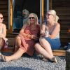 women talking outside wooden lodge
